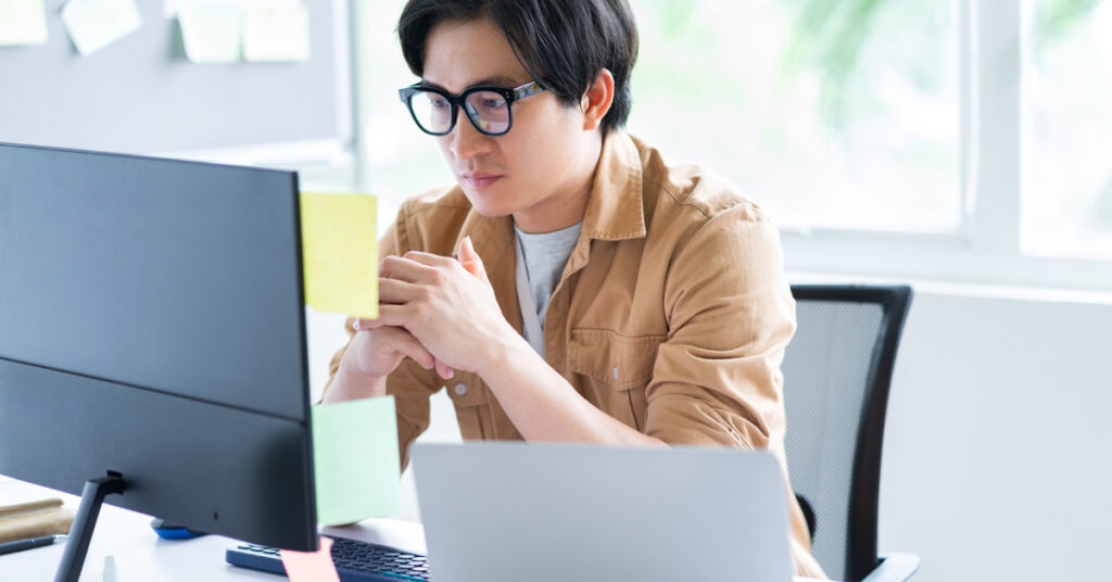 Man at computer thinking about Upwork costs